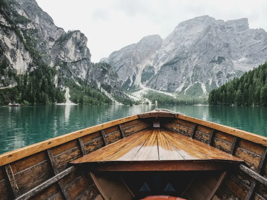 Barca de madera sobre un lago de montaña de aguas transparentes